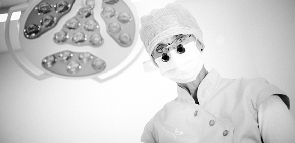 Frau Dr. Brumme im OP mit Mundschutz, OP-Haube und Lupenbrille