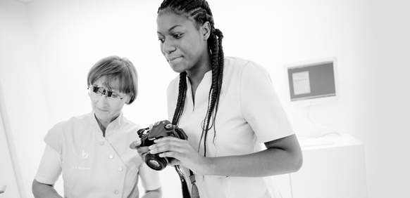 Dr. Sonja Brumme und Claudia Amankwatia mit Fotoapparat beim Dokumentieren des OP-Ergebnisses